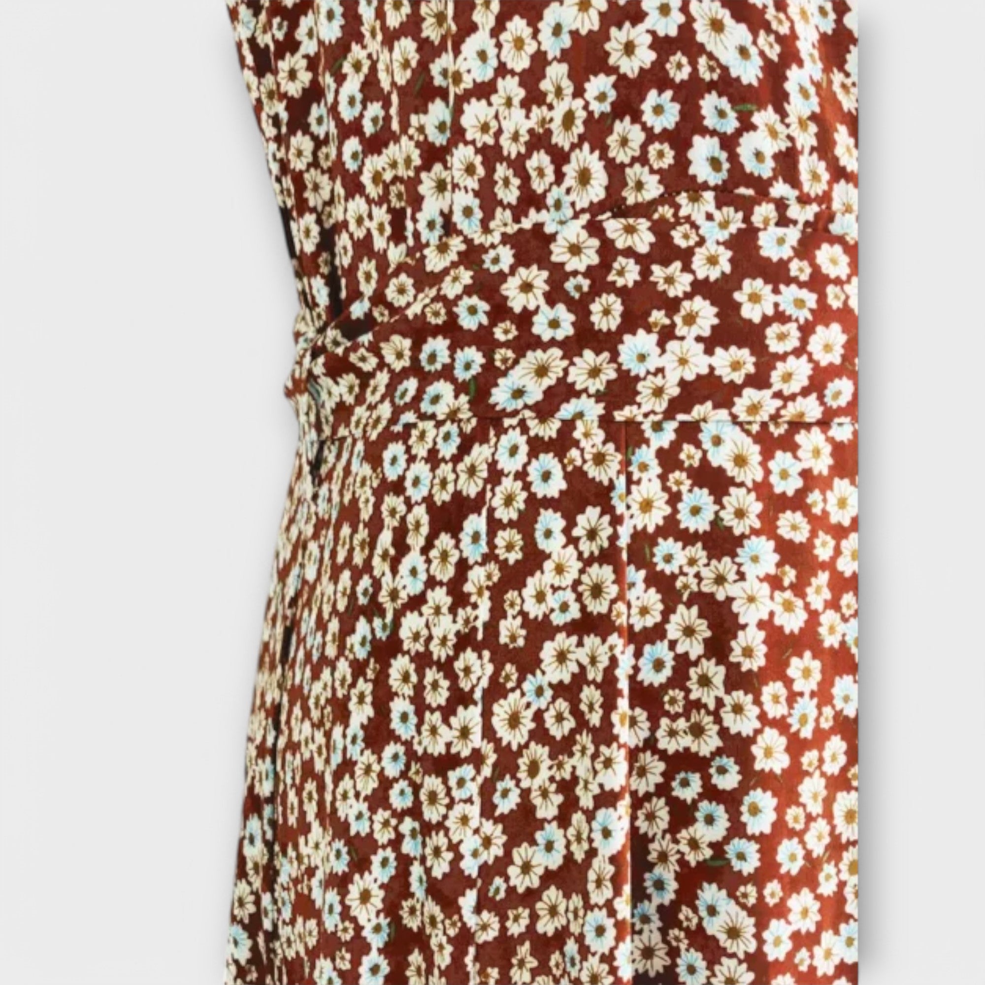 Stoffausschnitt vom Serephina Boho-Maxikleid mit weißem Blumenmuster auf braunem Grund