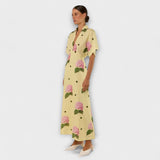 Langes gelbes Kleid mit Kurzarm und Blumenmuster aus rosa Blüten und schwarzen Punkten