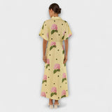 Rückansicht: Langes gelbes Kleid mit Kurzarm, rosa Blumen und schwarzen Punktakzenten
