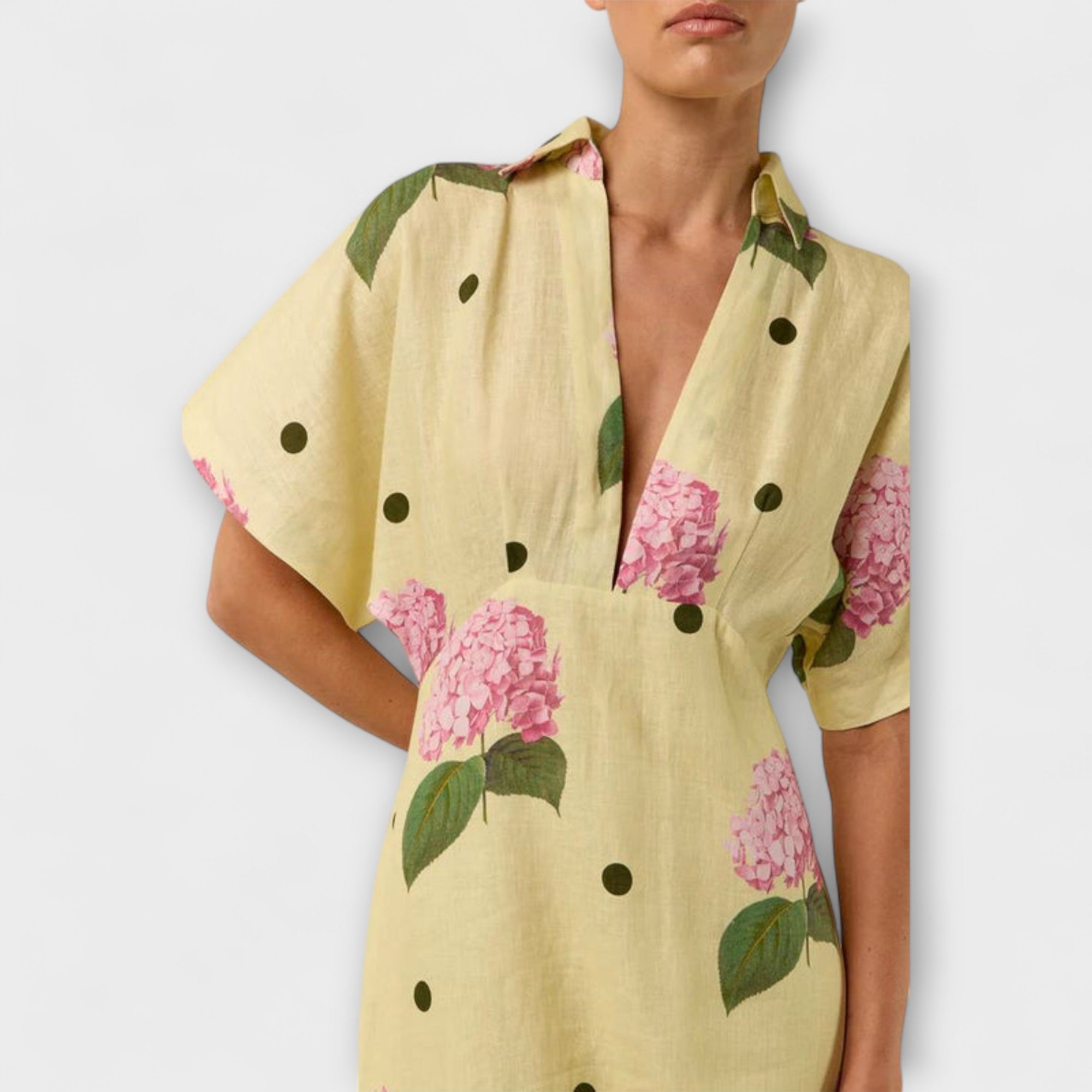 Gelbes Kleid mit V-Ausschnitt, Kurzarm und rosa Blüten sowie schwarzen Punkten