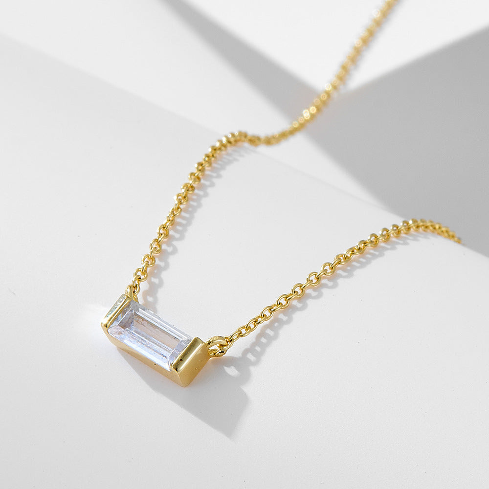 Goldene Halskette mit rechteckigem Anhänger und klarem Stein