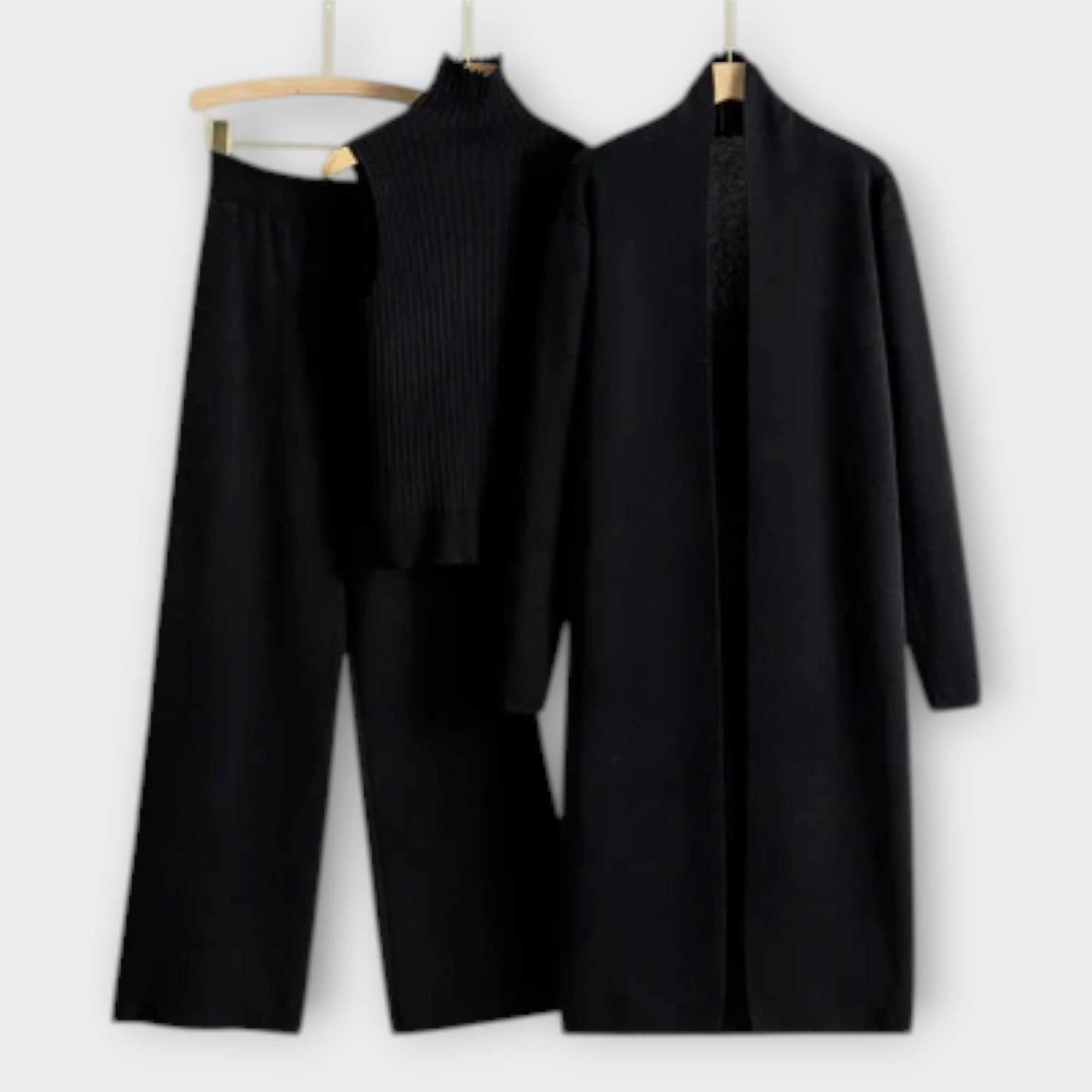 Schwarzer Dreiteiler mit Rippenstrick-Turtleneck, weiter Hose und langem Mantel