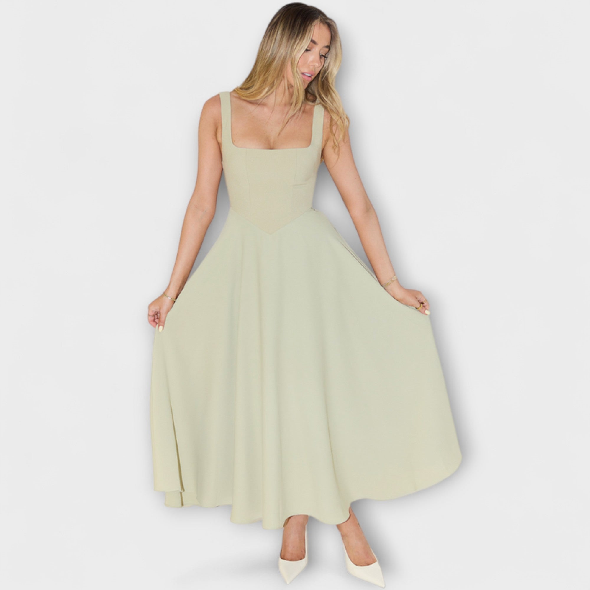 Salbeifarbenes Abendkleid mit eckigem Ausschnitt und weitem Midirock, seitlich getragen