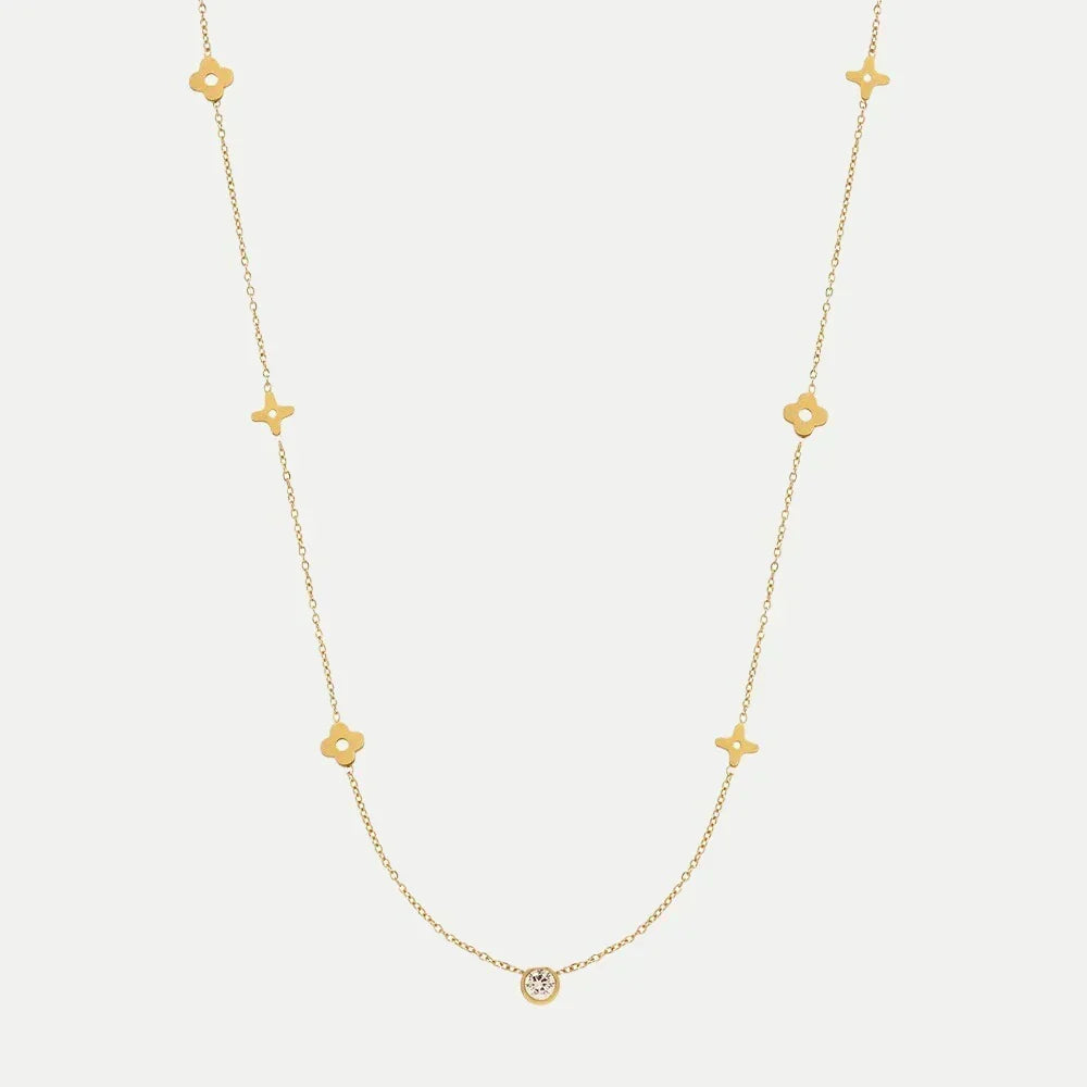 Goldene Kette mit kleinen Anhängern und rundem Stein am Ende