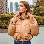 Camelfarbene Bomberjacke mit wattierter Steppung, Knopfleiste und Stehkragen.