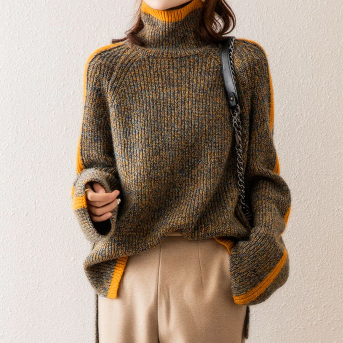 Rollkragenpullover aus meliertem Strick mit orangefarbenem Rand an Kragen, Ärmeln und Saum
