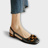 Schwarze Slingback-Sandale mit schmalen Riemen und goldfarbenen Zierelementen