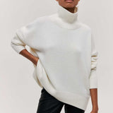 Weißer Rollkragenpullover mit geripptem Stehkragen und Ärmelbündchen, locker geschnitten.