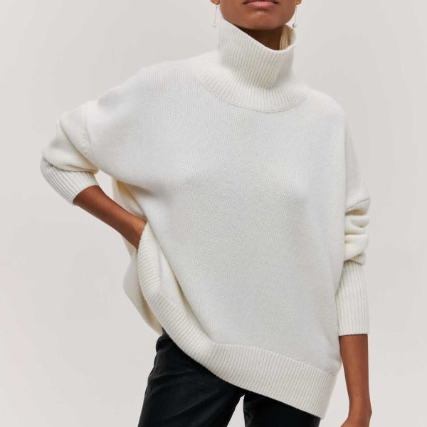 Weißer Rollkragenpullover mit geripptem Stehkragen und Ärmelbündchen, locker geschnitten.