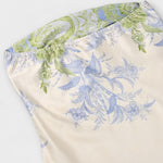 Detail Saum: cremefarbenes Kleid mit Pastell-Floralmuster und leichtem Volant