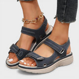 Dunkelblaue orthopädische Wedge-Sandale mit Riemen und Ketten-Detail am Knöchel