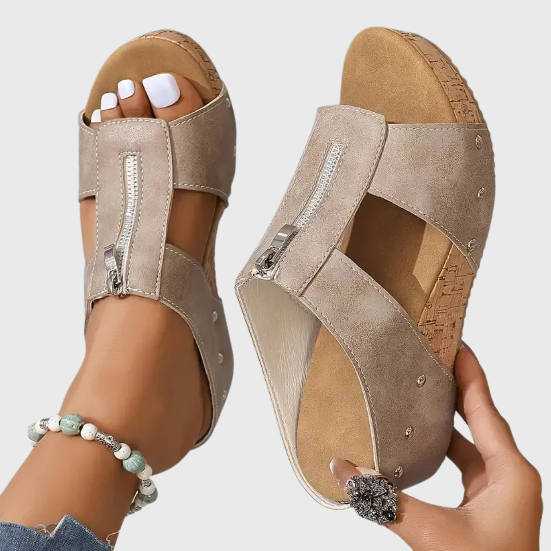 Beige Sandalen mit breiten Riemen, silbernem Reißverschluss-Einsatz und Korklaufsohle.