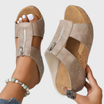 Beige Sandalen mit breiten Riemen, silbernem Reißverschluss-Einsatz und Korklaufsohle.