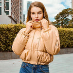 Beigefarbene Bomberjacke mit wattierter Steppung, Knopfleiste und Stehkragen.