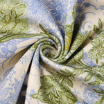 Stoffdetail: cremefarbenes Gewebe mit blau-grünen Floralmotiven im Allovermuster