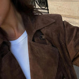 Nahaufnahme: Brauner Trenchcoat mit Knopf am Kragen und Abnäher an der Schulter