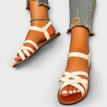 Weiße Sandalen mit breiten gekreuzten Riemen, offene Zehen und flache Sohle