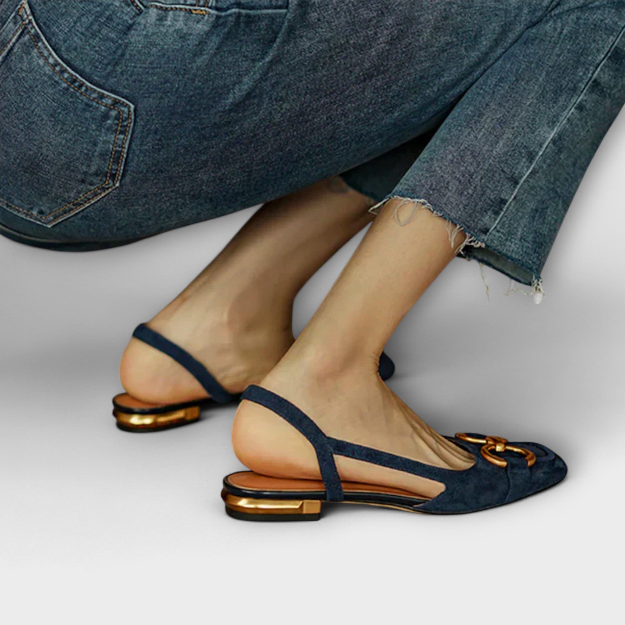 Dunkelblaue Slingback-Sandale mit schmalem Stegriemen und goldfarbenen Zierelementen