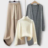Dreiteiliges Strick-Set: weißer Turtleneck-Pullover, grauer Strickcardigan, beiger Jogger