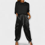 Zweiteiliges Set: schwarzes Satin-Top und Jogginghose mit Bindegürtel, Taschen
