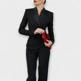Schwarzer Reversblazer mit langen Hosen im Set, taillierter Look und Knopfdetails.