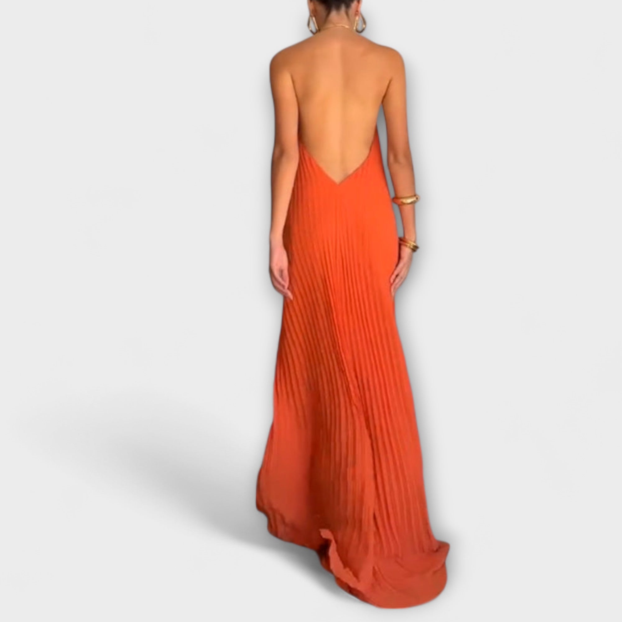 Oranges Plisseekleid Rückansicht mit tiefem Rückenausschnitt und langem Saum.