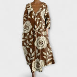 Langes Kleid mit V-Ausschnitt, 3/4-Ärmeln und besticktem Blütenmotiv in Braun und Beige.