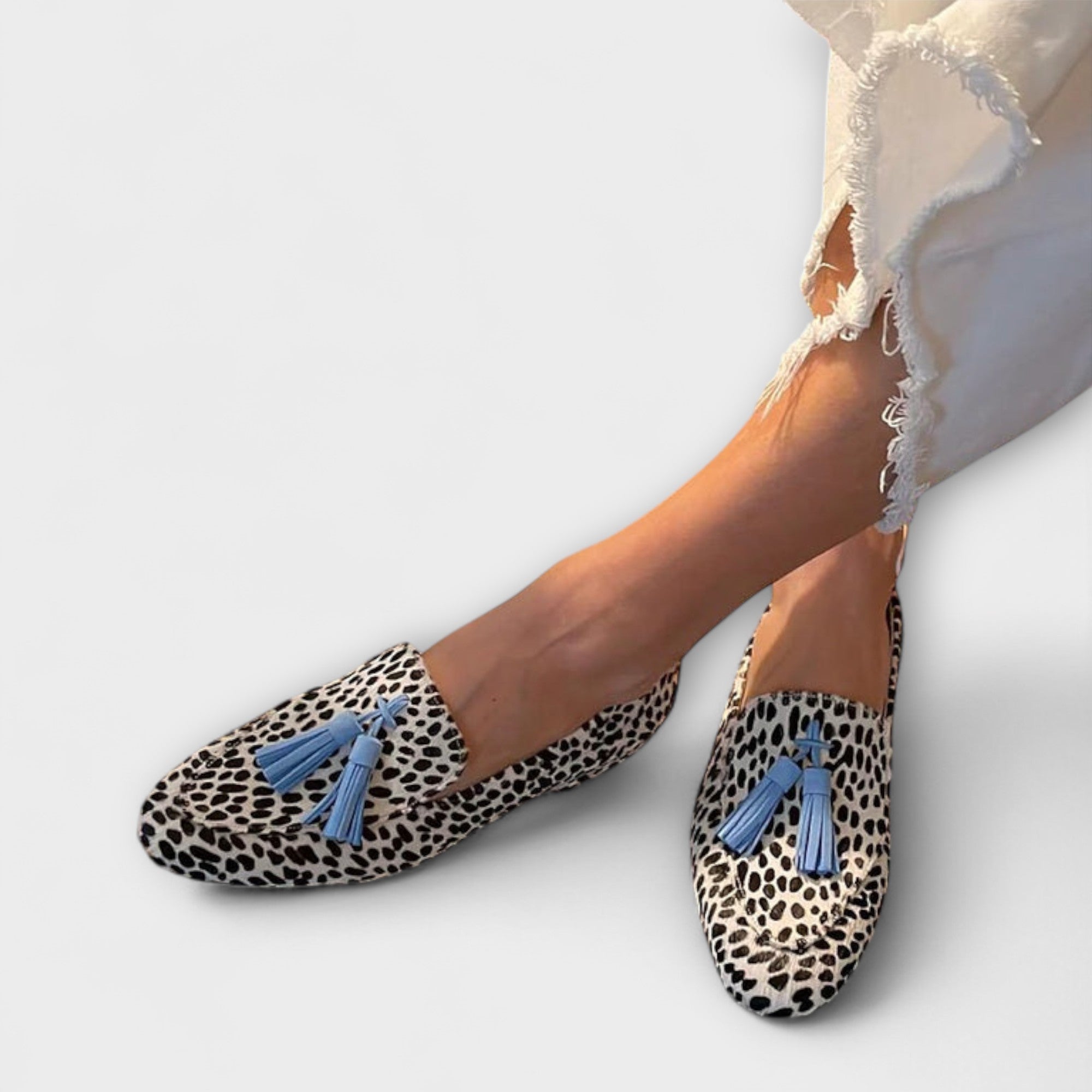 Loafer mit unregelmäßigem Punkte-Muster, hell mit schwarzen Sprenkeln und blauen Quasten