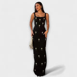 Schwarzes bodenlanges Perlenkleid mit breiten Trägern und silbernen Schmuckmotiven