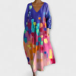 Langes Kleid mit V-Ausschnitt, 3/4-Ärmeln und buntem abstraktem Muster in Blau und Pink.