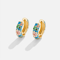 Goldene Creolenohrringe mit Blumenmotiv