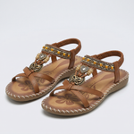 Boho-Sandalen braun, Lederriemen mit Schmuckanhänger, geflochtene Ziernähte, flach