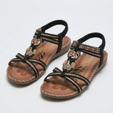 Boho-Sandalen braun mit schwarzen Riemen, Anhänger am Fußriemen, flache Sohle