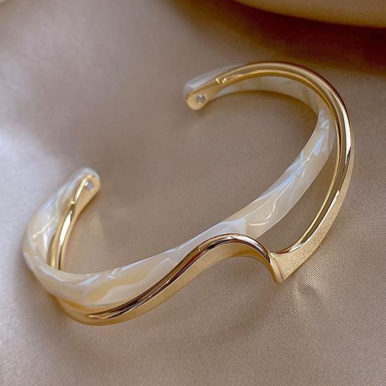 Goldfarbenes Armreif-Armband mit weißem Opal und gebogenem Design