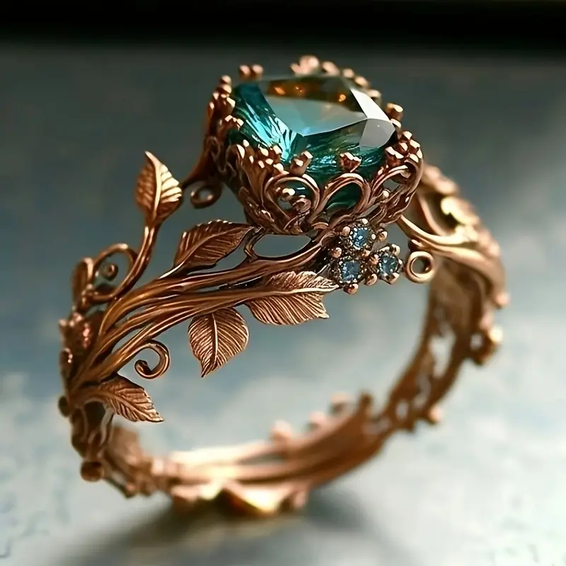 Ring mit grünem Kristall in filigraner Roségoldfassung, Zierblätter und kleine Steine
