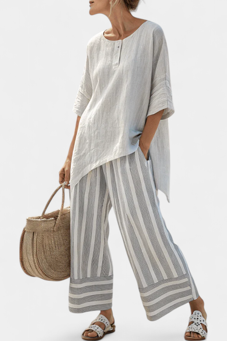 Asymmetrische Bluse mit Knopfleiste und schwingendem Ärmel, dazu gestreifte Hose