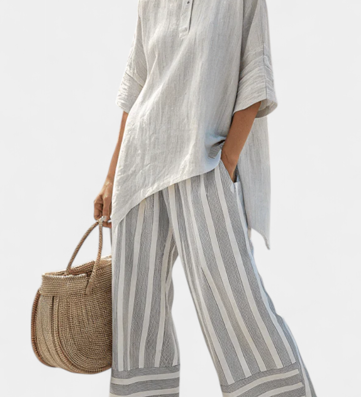 Asymmetrische Bluse mit Knopfleiste und schwingendem Ärmel, dazu gestreifte Hose