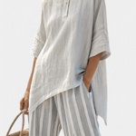 Asymmetrische Bluse mit Knopfleiste und gestreifter, weiter Hose in Hellgrau