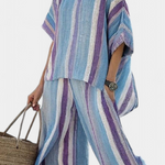 Gestreifter Streifenanzug mit weitem Shirt und Hose, türkis-lila-blaue Streifen und Knopfdetail