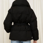 Schwarze Steppjacke von hinten mit Kapuze und Taillengürtel