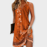 Orangenes Midi-Kleid, ärmellos mit V-Ausschnitt und Knopfleiste, florales Muster am Saum.