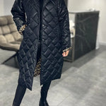 Schwarzer Steppmantel mit geradem Schnitt, verdeckter Knopfleiste und Leoprint-Details an den Ärmeln