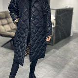 Schwarzer Steppmantel mit geradem Schnitt, verdeckter Knopfleiste und Leoprint-Details an den Ärmeln