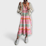 Lockeres Kleid mit weitem Rock, V-Ausschnitt und langen Puffärmeln; buntes Muster in Pink/Grün
