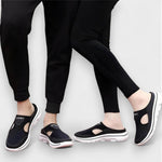 Dunkle Sportsandalen mit offener Front und dicker Profilsohle, am Fuß getragen