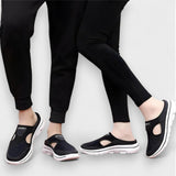 Dunkle Sportsandalen mit offener Front und dicker Profilsohle, am Fuß getragen