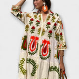 Weißes Hemdblusenkleid mit V-Ausschnitt und Blumenstickerei in Rot und Grün.